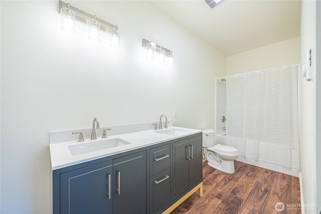 bathroom featuring shower / tub combination, a sink, toilet, and wood finished floors