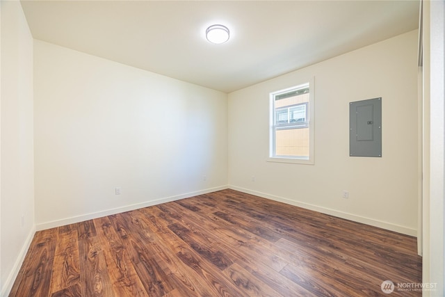 unfurnished room with electric panel, baseboards, and dark wood-style flooring