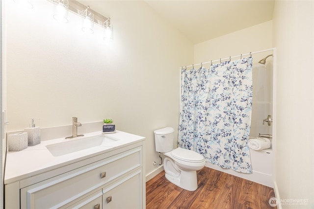 bathroom with toilet, a shower with shower curtain, wood finished floors, vanity, and baseboards