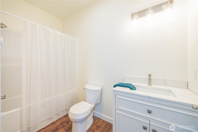 full bathroom featuring toilet, shower / tub combo, wood finished floors, vanity, and baseboards