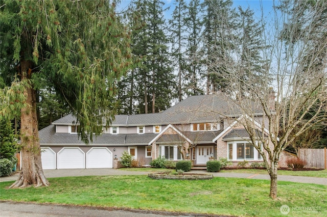 view of front of home with a garage, driveway, a front lawn, and fence