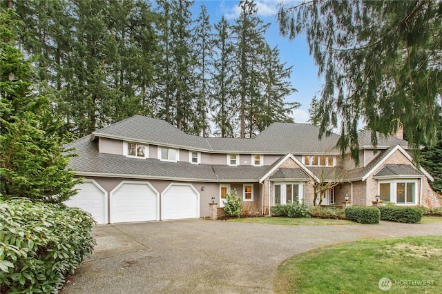 view of front facade featuring driveway, a garage, and a front yard