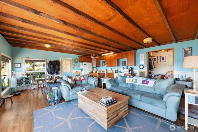 living room with beamed ceiling and wood finished floors