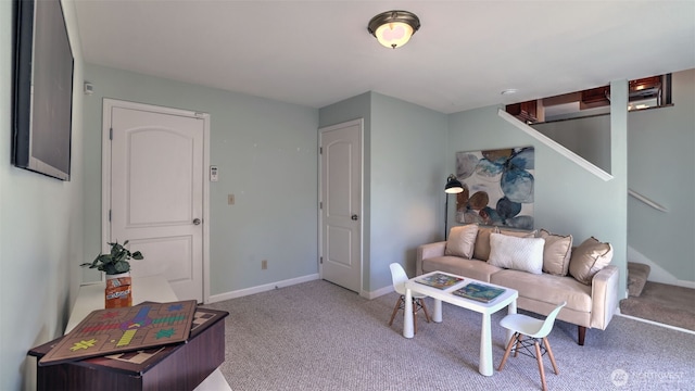 living room featuring carpet floors, baseboards, and stairs