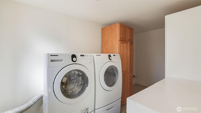 clothes washing area with independent washer and dryer and cabinet space