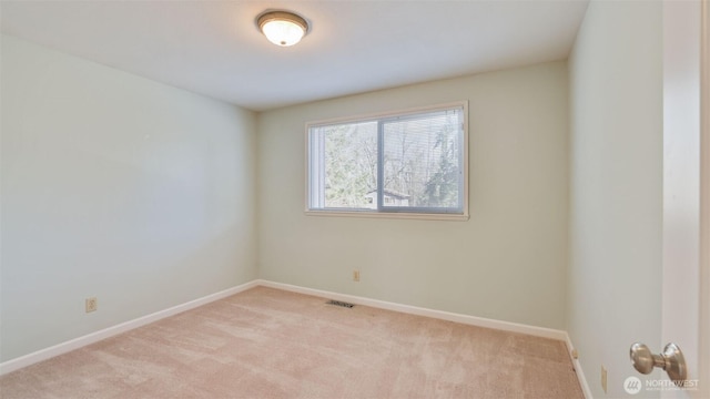 unfurnished room featuring light colored carpet, visible vents, and baseboards