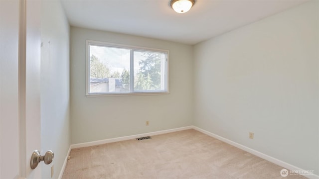 unfurnished room featuring light carpet, visible vents, and baseboards