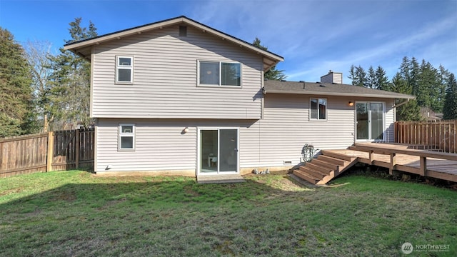 rear view of property featuring a fenced backyard, a lawn, and a wooden deck