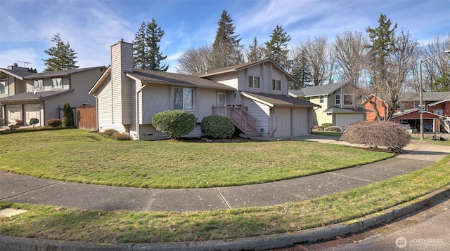 tri-level home featuring a garage, concrete driveway, a front lawn, and a chimney