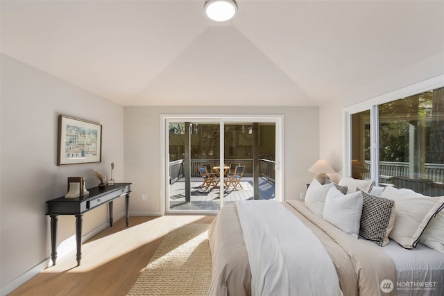 bedroom featuring lofted ceiling, access to outside, and baseboards