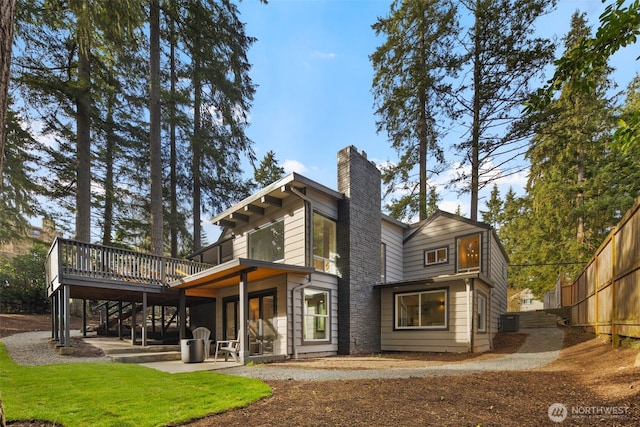 rear view of property with a chimney, a patio area, fence, cooling unit, and a wooden deck