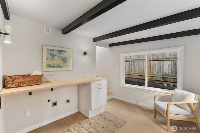 interior space with light wood finished floors, beamed ceiling, visible vents, and baseboards