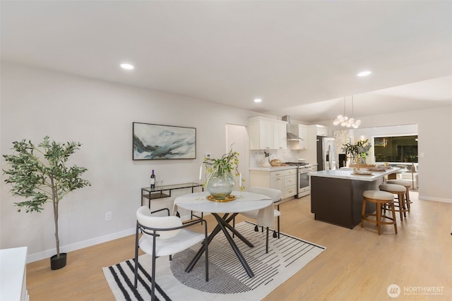 dining area featuring baseboards, light wood finished floors, an inviting chandelier, and recessed lighting