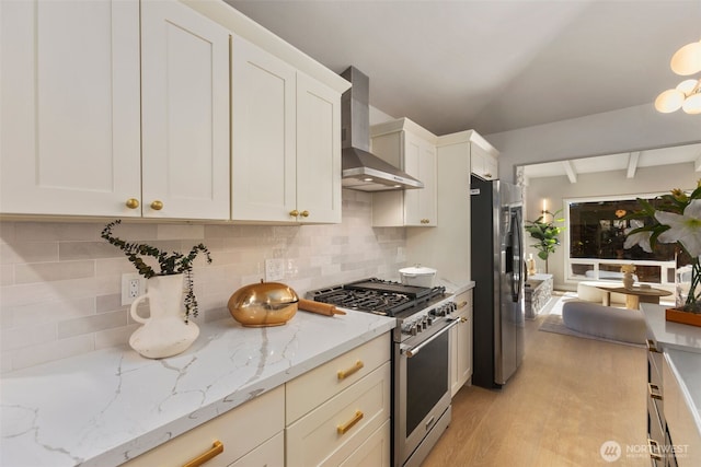 kitchen featuring white cabinets, light wood-style floors, appliances with stainless steel finishes, decorative backsplash, and wall chimney exhaust hood