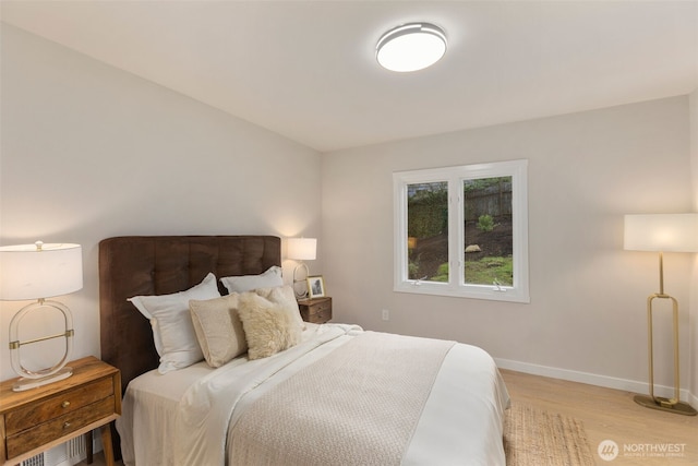 bedroom with light wood-style floors and baseboards