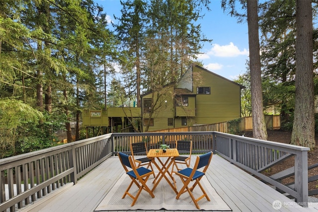 wooden terrace featuring outdoor dining space and fence