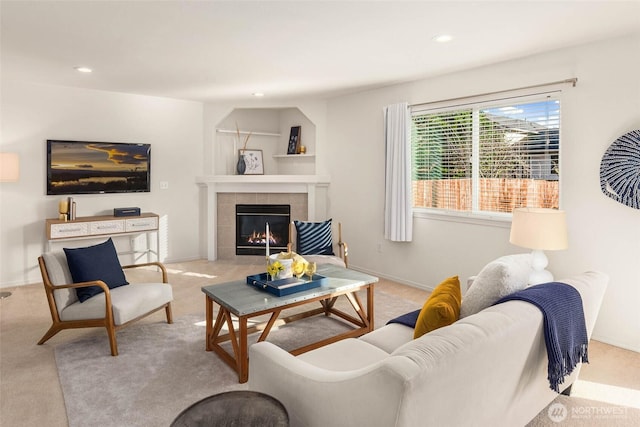 living area with baseboards, carpet flooring, a tile fireplace, and recessed lighting