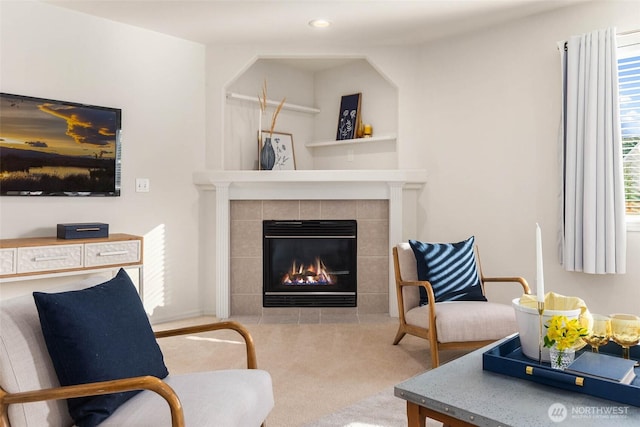 living area featuring carpet, a tiled fireplace, and recessed lighting