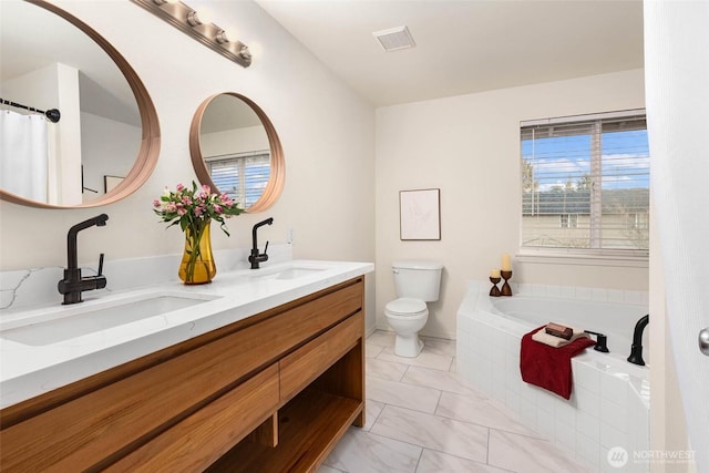 full bathroom featuring toilet, visible vents, a sink, and a bath