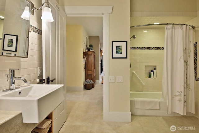 full bath with a sink, tasteful backsplash, shower / bath combo, and tile patterned floors