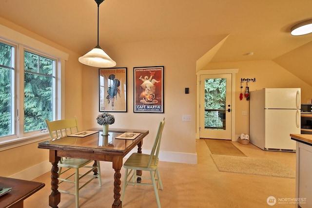 dining area with baseboards and vaulted ceiling