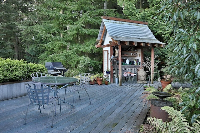 wooden terrace with grilling area and outdoor dining space