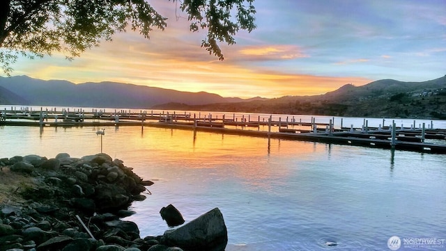 property view of water with a dock and a mountain view