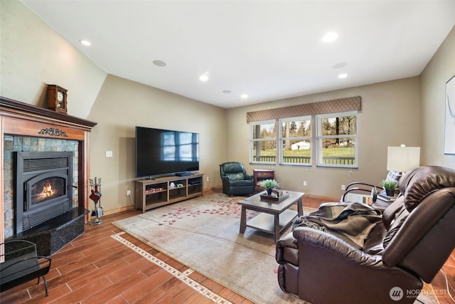 living room with baseboards, a tiled fireplace, wood finished floors, and recessed lighting