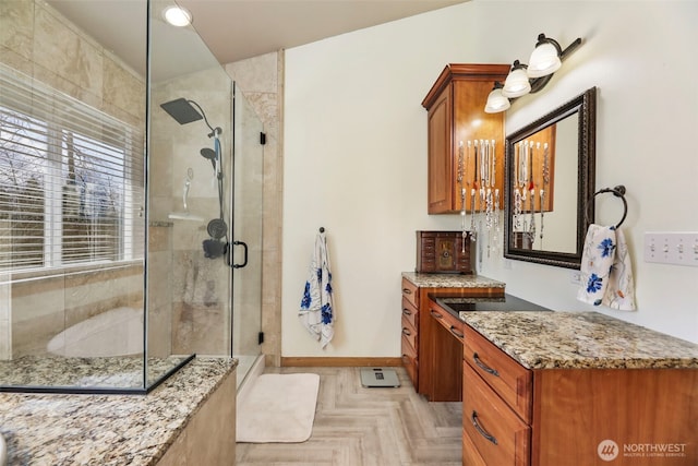 bathroom featuring a stall shower, vanity, and baseboards