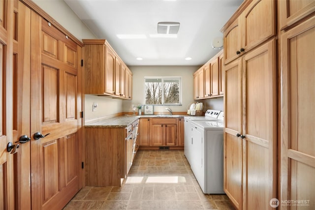 kitchen featuring recessed lighting, a sink, and washing machine and clothes dryer