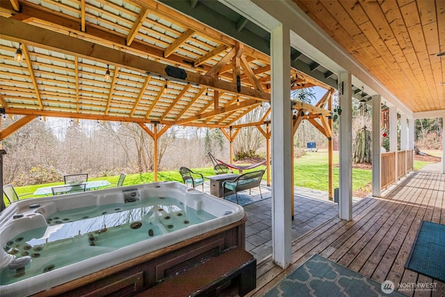 wooden deck featuring a yard and a hot tub