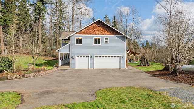 view of side of home featuring a garage, driveway, and a lawn