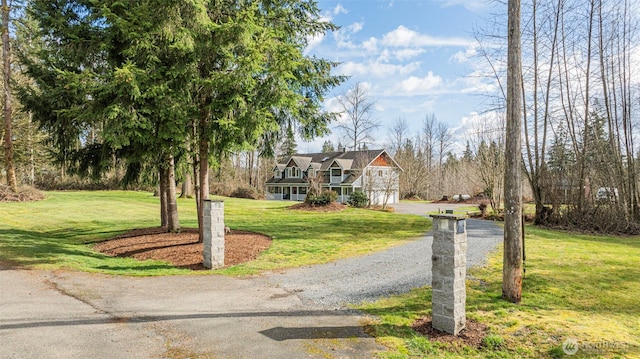 view of front of property featuring driveway, a garage, and a front yard