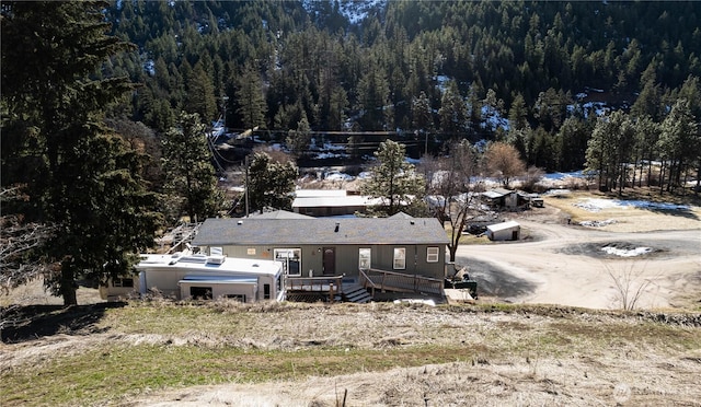 exterior space with a forest view and a wooden deck