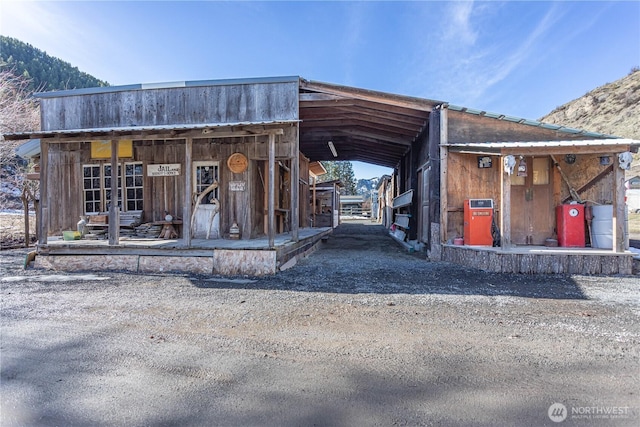 exterior space with an outbuilding, driveway, an attached carport, and a mountain view