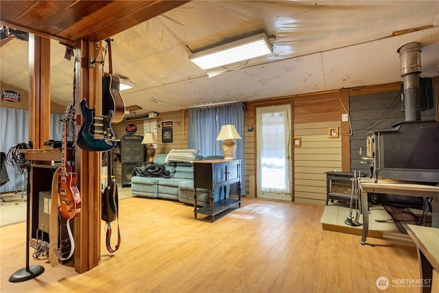 miscellaneous room featuring a wood stove, wood walls, and wood finished floors