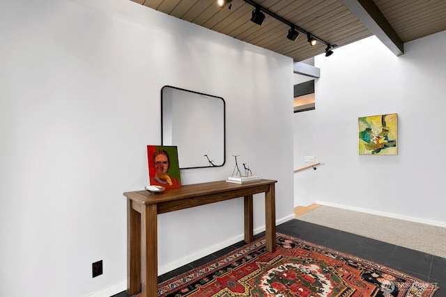 corridor with baseboards, wooden ceiling, and track lighting