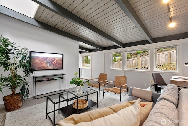 carpeted living room featuring beam ceiling