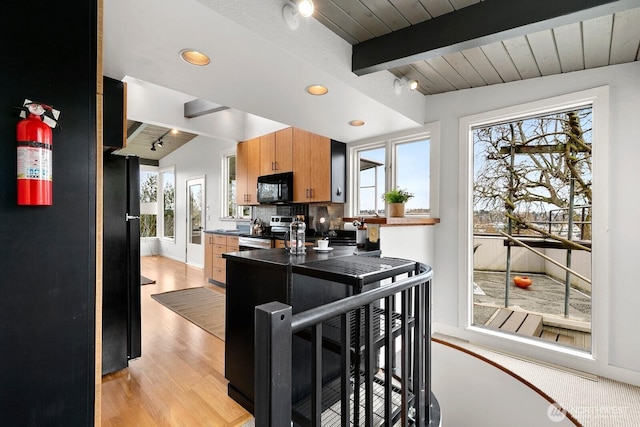 kitchen featuring black appliances, dark countertops, tasteful backsplash, and a wealth of natural light