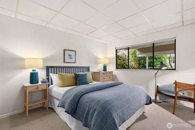 bedroom with a drop ceiling and carpet floors