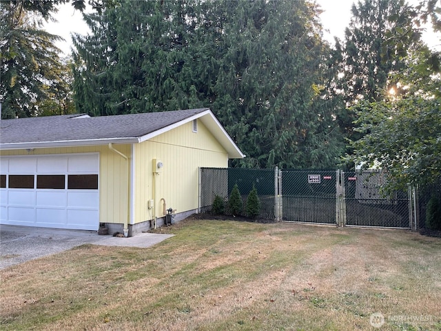 view of side of home featuring a shingled roof, a lawn, and fence