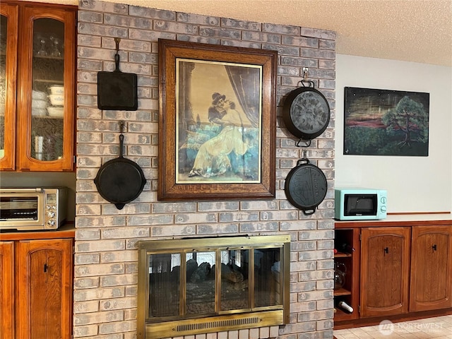 room details with a brick fireplace, a toaster, a textured ceiling, and white microwave