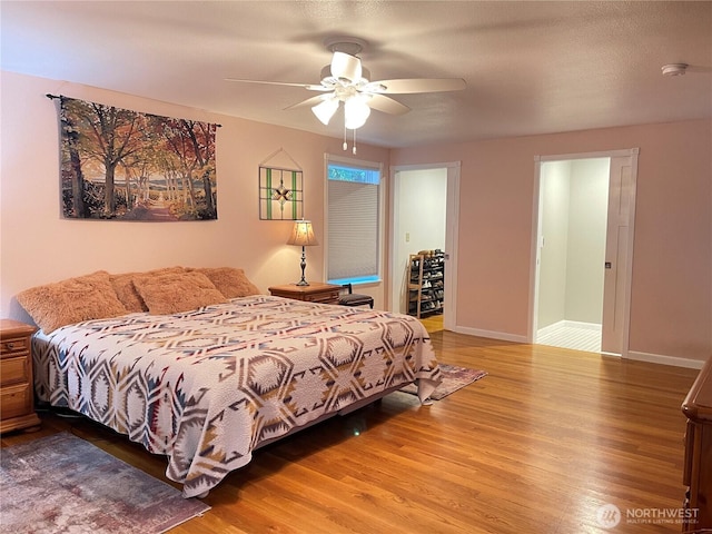 bedroom with a ceiling fan, baseboards, and wood finished floors