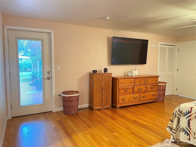 living area with light wood-style flooring and baseboards