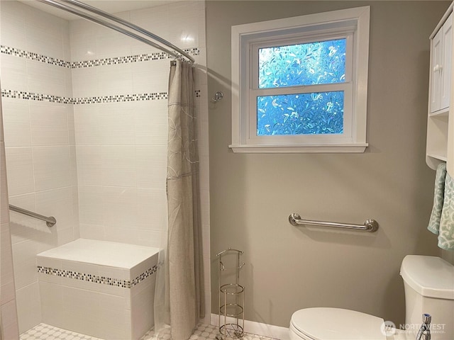 full bath featuring baseboards, a shower stall, and toilet