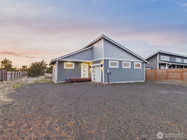 view of front of property featuring driveway and fence