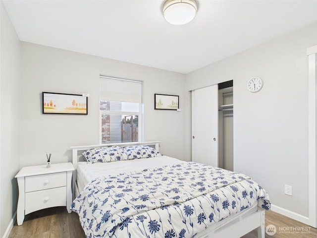 bedroom featuring dark wood-style floors, baseboards, and a closet