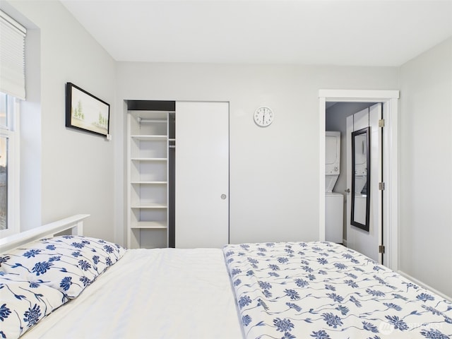 bedroom with a closet and stacked washer / dryer