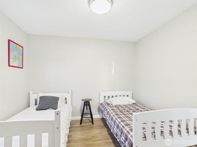 bedroom with wood finished floors and baseboards