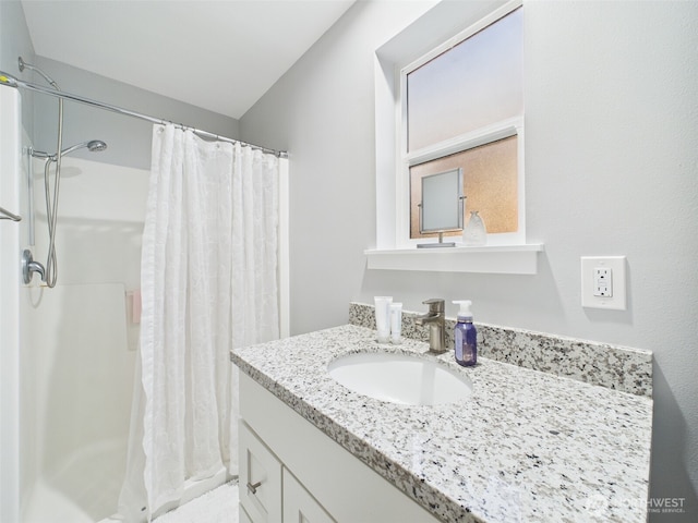 bathroom featuring curtained shower and vanity